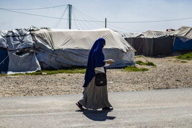 Une femme traverse le camp Roj en Syrie.