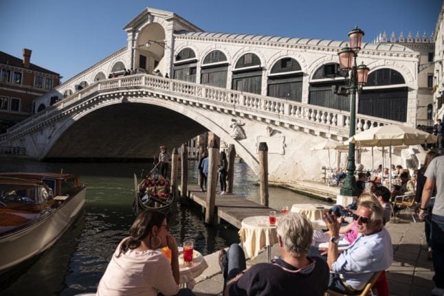 Touriste assis dans un café près du pont du Rialto à Venise.