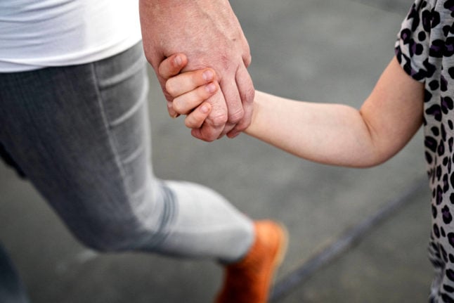 Un père tenant la main d'un enfant
